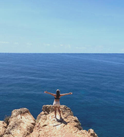 Openness and freedom in your process Flor with open arms facing the sea, symbolizing openness, freedom, and inner connection in an Akashic Records session